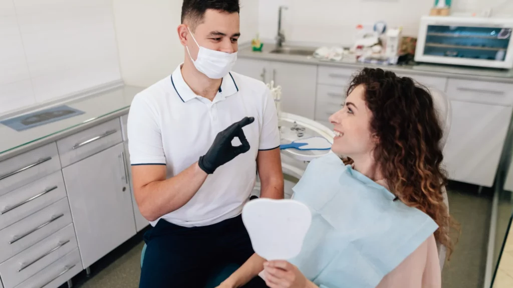 an oral surgeon approving of a woman's new dental implants